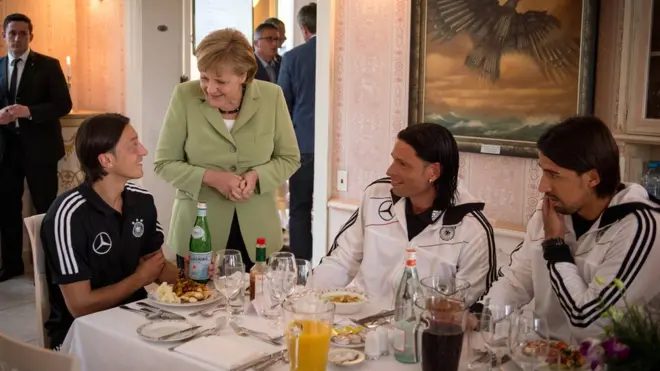 Thủ tướng Angela Merkel nói chuyện với Mesut Ozil (bìa trái, ngồi) ở Ba Lan khi tuyển Đức sang tham dự giải Euro 2012