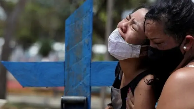 Woman reacts during the burial of her mother in Manaus