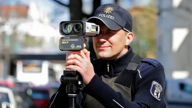 A German police officer holds a portable laser speed trap to his eye in this 2016 file photo