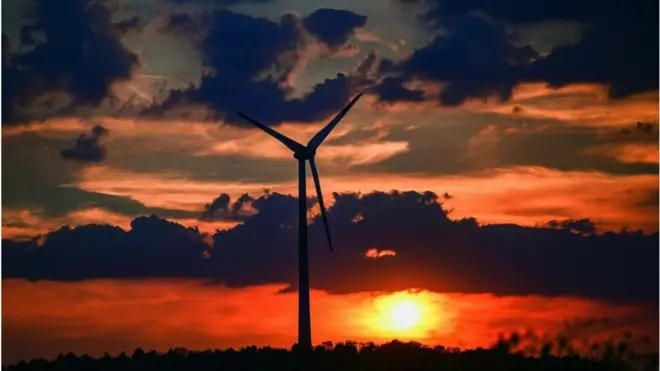 독일의 풍력 발전기 뒤로 해가 지고 있다