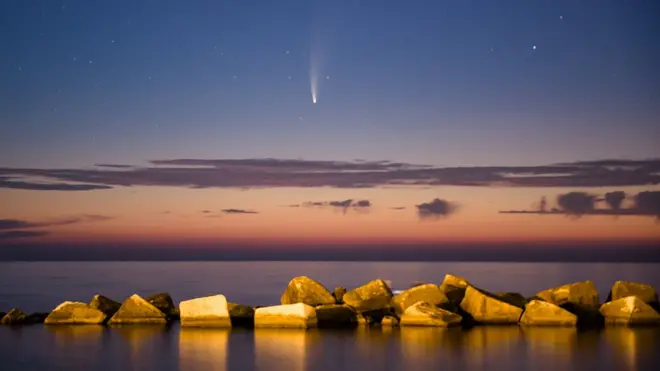 The comet, seen here above the Port of Molfetta in Italy, will pass closest to Earth on 23 July