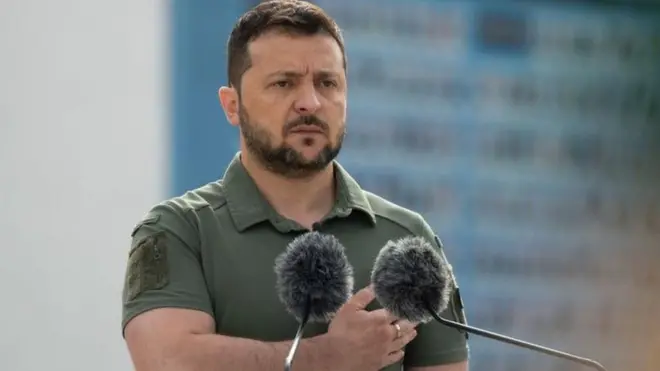 Volodymyr Zelensky standing behind a podium