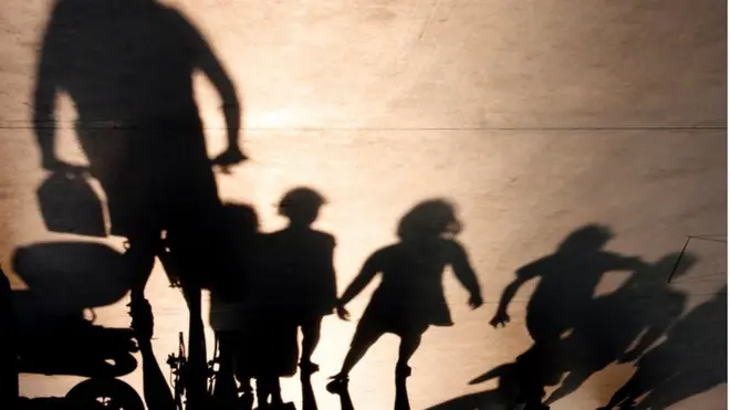 Shadowy adult with shadowy children