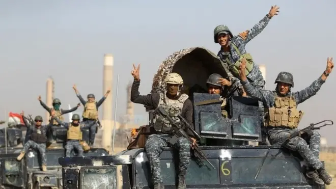 Iraqi forces flash a victory sign while driving past an oil production plant near Kirkuk. Photo: 16 October 2017