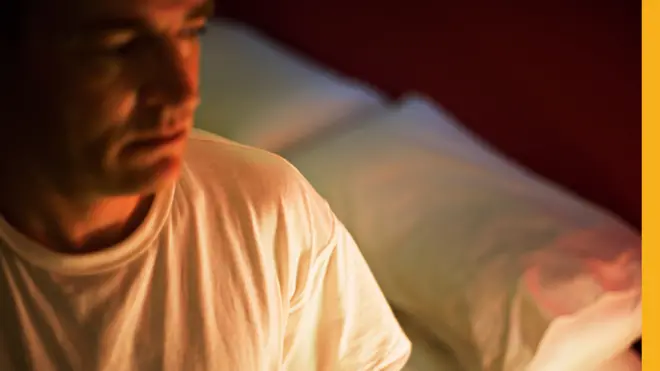 Hombre sentado en una cama