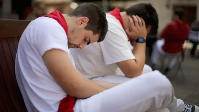 Dua peserta adu banteng di Pamplona, Spanyol, tidur siang saat jeda pada ajang tahunan Fiesta de San Fermin.