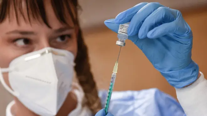 Medical personal fills a syringe with the Biontech Pfizer vaccine in a vaccination station at the Stephanus church in Stuttgart, southern Germany, on November 16, 2021.