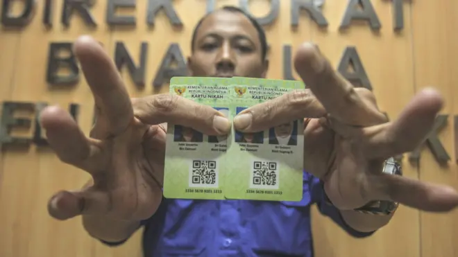 Petugas Kementerian Agama (Kemenag) menunjukan Kartu Nikah di kantor Kemenag, Jakarta, Senin (12/11). Kartu nikah dibuat untuk meminimalisir praktik pemalsuan buku nikah