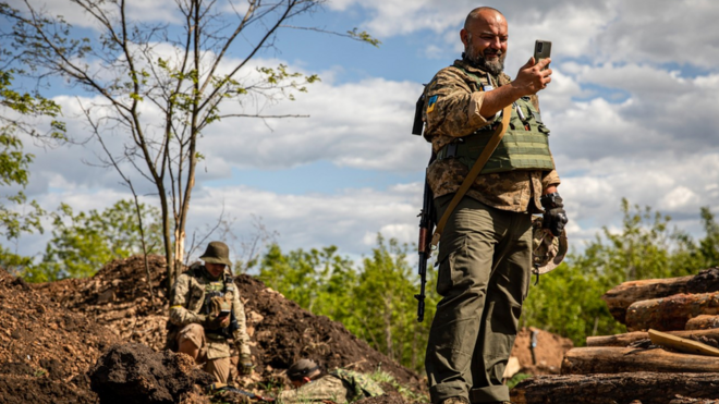 جندي أوكراني يتواصل على هاتف محمول باستخدام ستارلينك