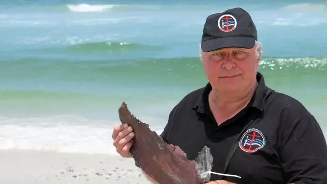 برونو ويرز يحمل قطعة من النحاس يرجح أنها من بقايا دفة سفينة نيو هارلم