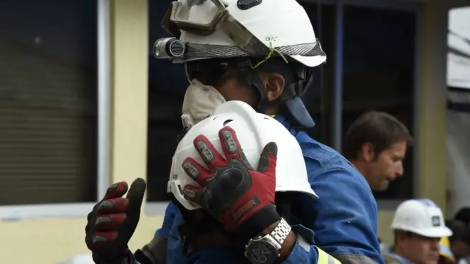 Dos rescatistas se abrazan en las inmediaciones de la escuela Enrique Rébsamen.