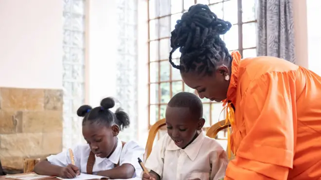 African mama dey help her son and daughter wit homework 