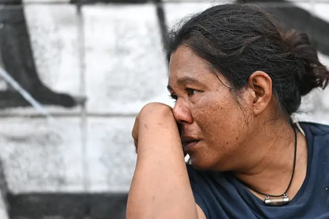 A woman looks on as she waits for news of a missing family member at the site of an under-construction building collapse in Bangkok. 