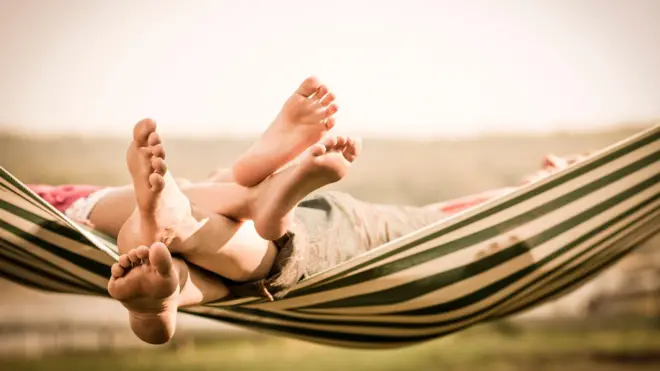 Os pés de uma mãe e filha numa rede