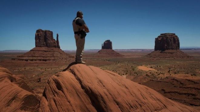A Navajo park ranger looks out over Navajo Nation-managed Monument Valley