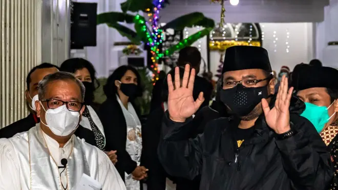 Menteri Agama Yaqut Cholil Qoumas (kanan) didampingi Pendeta Yorinawa Salawangi (kiri) melambaikan tangan kepada wartawan saat meninjau pelaksanaan ibadah Misa Natal di Gereja GPIB Imanuel (Gereja Blenduk) Semarang, Jawa Tengah, Kamis (24/12/2020).