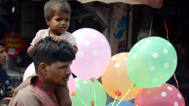 मुलीला कडेवर घेऊन जाणारा पिता