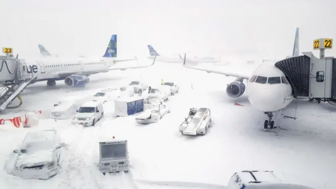 Sejumlah pesawat di Bandara Internasional John F. Kennedy tertutup salju. Hampir 40.000 penerbangan dibatalkan di seluruh AS.