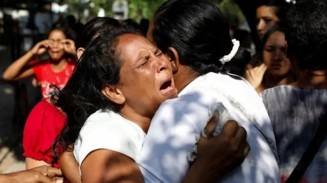 Relatives of inmates held at the General Command of the Carabobo Police react as they wait outside the prison, where a fire occurred in the cells area, according to local media, in Valencia, Venezuela, 28 March