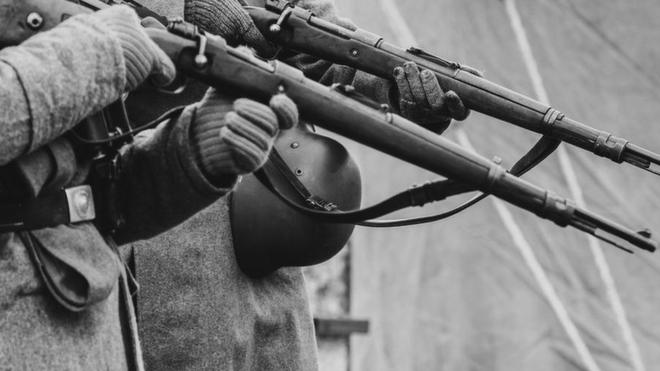 Unos soldados nazis apuntando sus rifles.