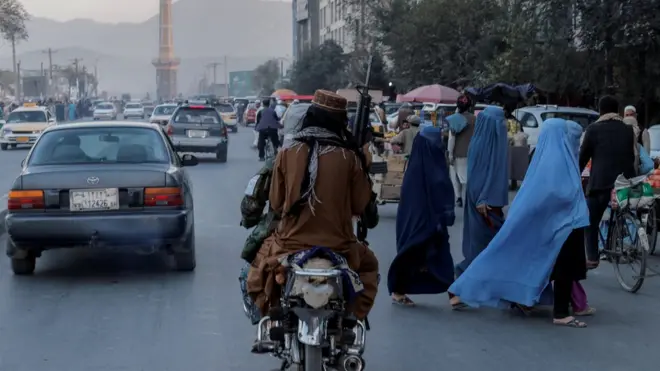 Perempuan Afghanistan di Kabul menyeberang jalan ketika Taliban lewat