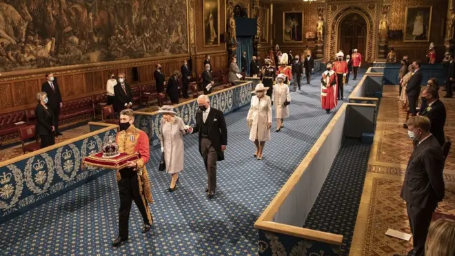 Queen Elizabeth II, accompanied by the Prince of Wales, proceeds through the Royal Gallery before delivering the Queen"s Speech during the State Opening of Parliament in the House of Lords at the Palace of Westminster in London