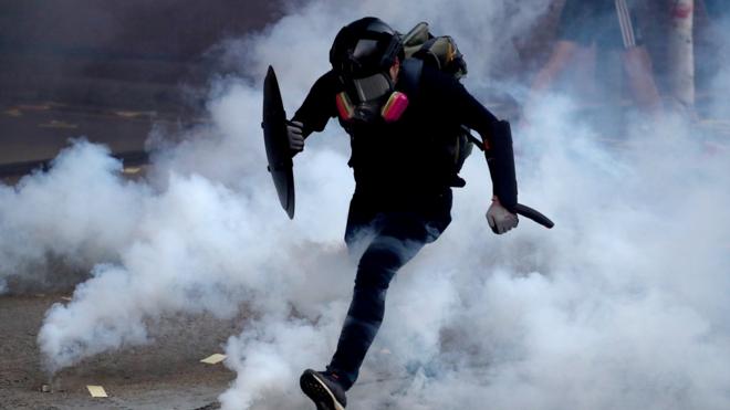 香港九龙深水埗一名示威者在催泪瓦斯烟雾中奔跑（1/10/2029）