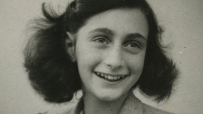 Anne Frank sorri numa foto em preto e branco
