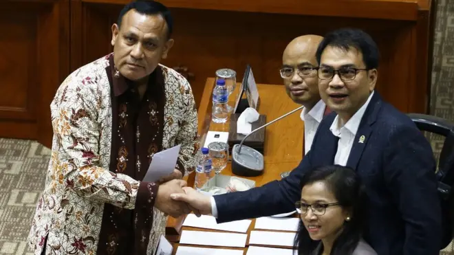 Calon Pimpinan KPK, Irjen pol Firli Bahuri (kiri), berjabat tangan dengan Ketua Komisi III DPR Aziz Syamsuddin usai menerima amplop berisi tema makalah yang harus dibuat, saat uji kelayakan dan kepatutan calon pimpinan KPK di Kompleks Parlemen, Senin (9/9).