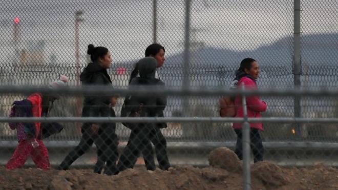 Migrants walk along the US-Mexican border in El Paso, Texas, 10 February