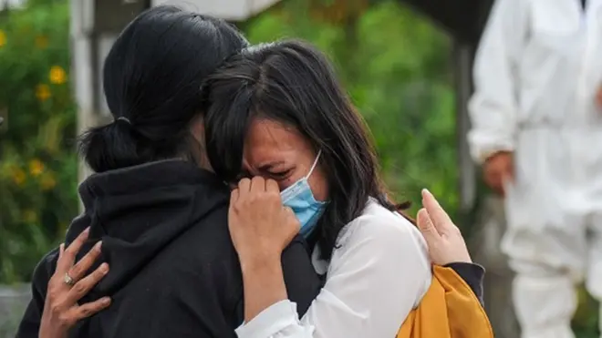 Keluarga menangis saat menyaksikan pemakaman jenazah dengan protokol Covid-19 di TPU Cikadut, Bandung, Jawa Barat, Selasa (15/06). Petugas pikul jenazah mengatakan, pemakaman jenazah dengan protokol Covid-19 di TPU Cikadut mengalami peningkatan sebanyak 20 hingga 30 jenazah per hari dibandingkan dengan bulan lalu yang hanya lima hingga delapan jenazah per hari.