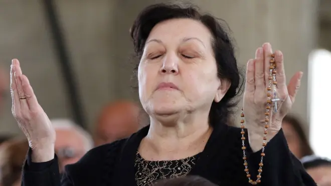 حاجة مسيحية تصلي خلال القداس الذي أقيم في "كنيسة العمادة" بموقع "المغطس" في الأردن