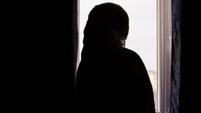 امرأة تنظر من إحدى النوافذ