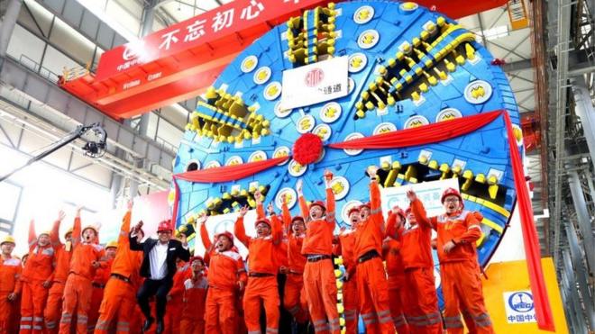 Trabalhadores chineses próximos a uma das super máquinas que estão sendo usadas em projetos de infraestrutura dentro e fora do país