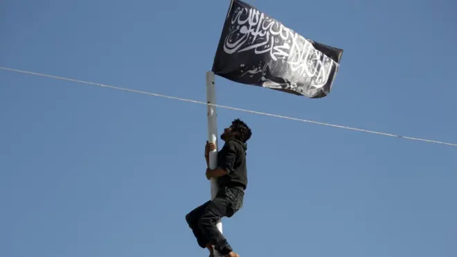 Nusra üyesi bayrağa uzanıyor