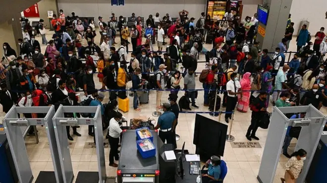 Passengers stand in queues at the Colombo International Airport in Katunayake on September 26, 2022