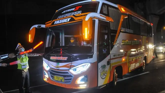Polisi menghalau bus yang membawa pemudik di tol Jakarta-Cikampek untuk keluar ke Gerbang tol Cikarang Barat, Kabupaten Bekasi, Jawa Barat, Jumat (24/4). Akses transportasi mobil pribadi dan bus angkutan penumpang dari tol Jakarta Cikampek menuju Karawang ditutup mulai Jumat (24/4) pukul 00.00 WIB.