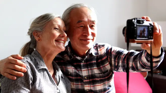 Пожилые мужчина и женщина фотографируют себя
