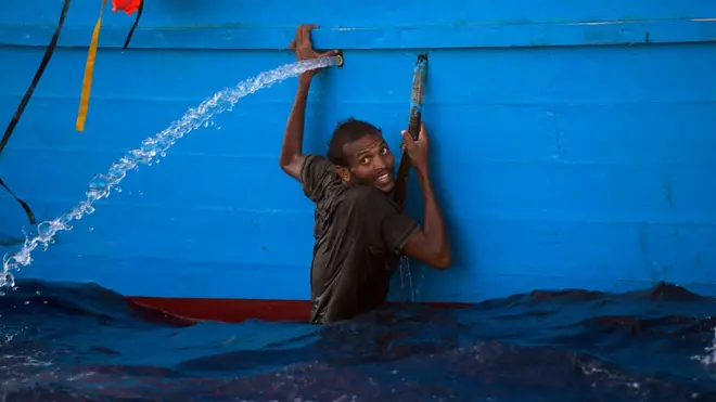 Tekneye tutunan bir Afrikalı göçmen