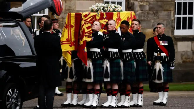 Pallbearers carrying the coffin of Queen Elizabeth II, draped with the Royal Standard of Scotland, as it arrives at Holyroodhouse, Edinburgh where it will lie in rest for a day.
