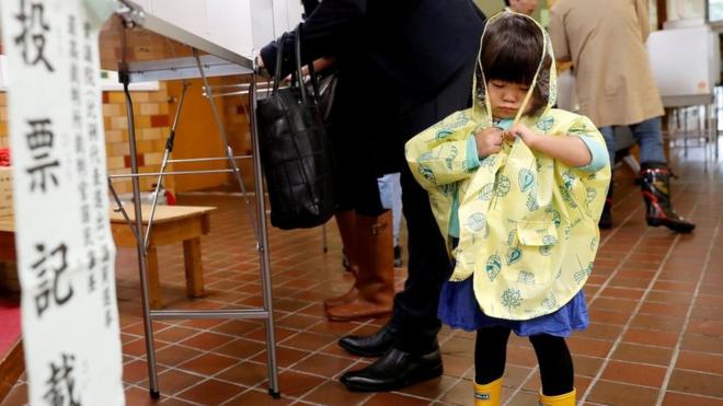 日本民眾冒著風雨前往投票。