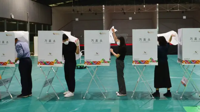 투표소에서 관계자들이 기표소 등을 최종 점검하고 있다