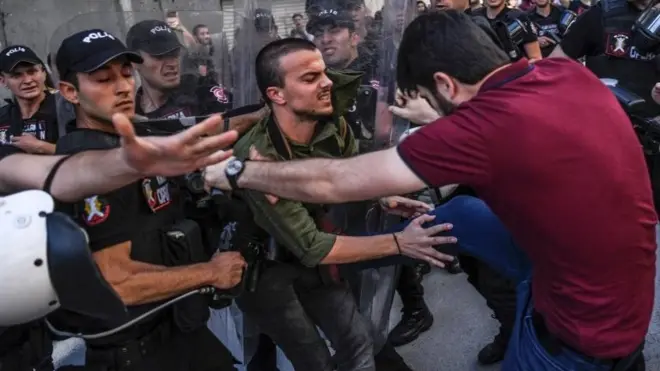 AFP haber ajansı geçtiği bu fotoğrafında sivil giyimli bir polisin LGBTİ aktivistine tekme attığını belirtti.