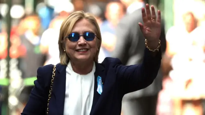 Clinton saluda a los fotógrafos al salir de la casa de su hija en Nueva York.