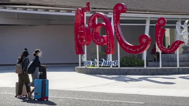 Penumpang domestik tiba di Bandara Ngurah Rai, Bali, dengan mengenakan pelindung wajah. Bali membuka diri untuk turis domestik, namun menunda pembukaan untuk turis mancanegara.