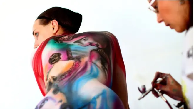 An artist paints a model during the World Bodypainting Festival 2018