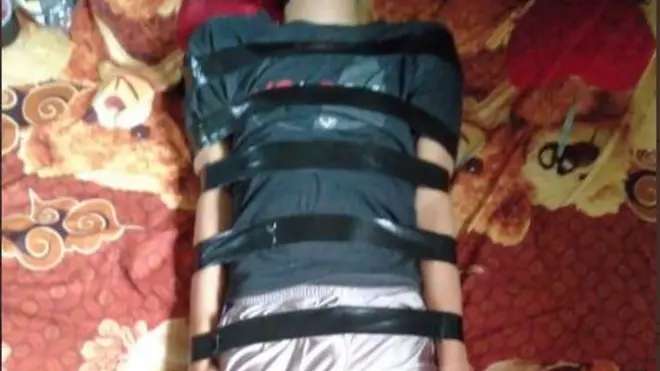 Foto Mufis saat hendak dibungkus kain sebagaimaan ditampilkan dalam utas Twitter.