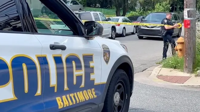 A police officer secures crime scene tape to a pole after a mass shooting at the scene of a Fourth of July holiday weekend block party in Baltimore, Maryland, U.S. July 2, 2023.