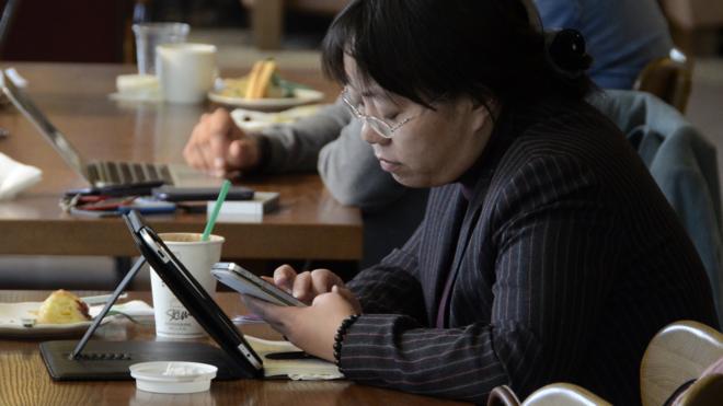 北京某咖啡店內顧客用智能手機和平板電腦上網（資料圖片）