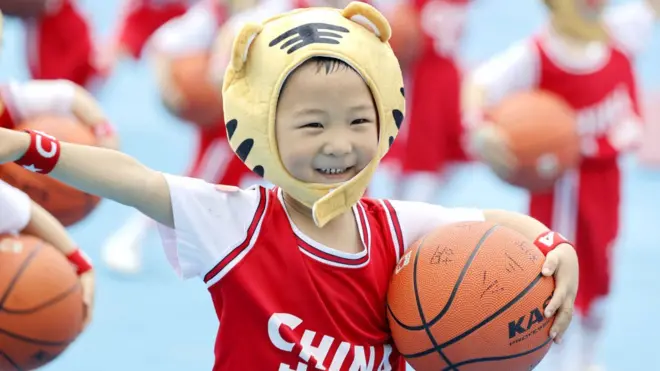 Menino chinês com camisa da China e bola de basquete